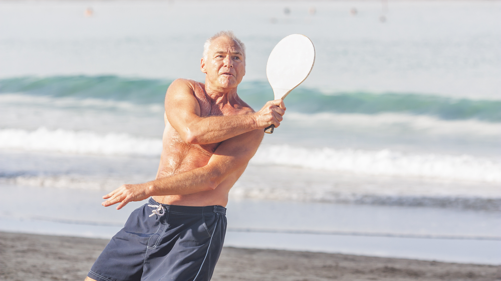 Man playing tennis on the beach