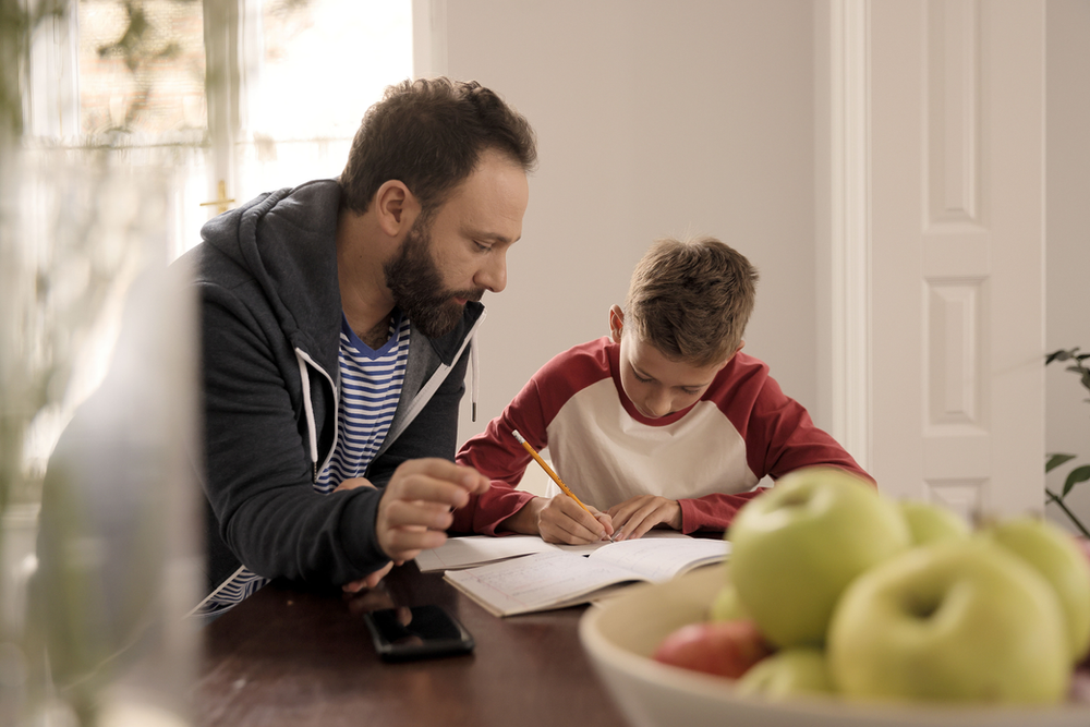 A man watching his child study