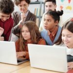 A Two Girls Using Laptop with Classmates